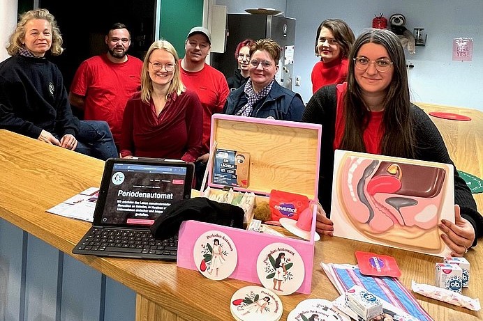 Mitarbeiter/innen der OASE und Clubmitglieder bei der Übergabe des Periodenautomaten