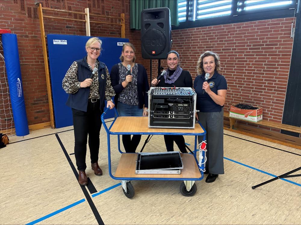 Schulleitung und Lions mit Mikros und der neuen Musikanlage